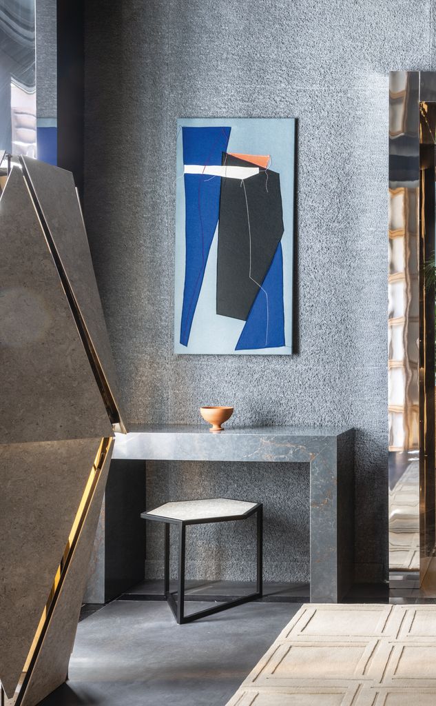 Consola de silestone gris apoyada en la pared