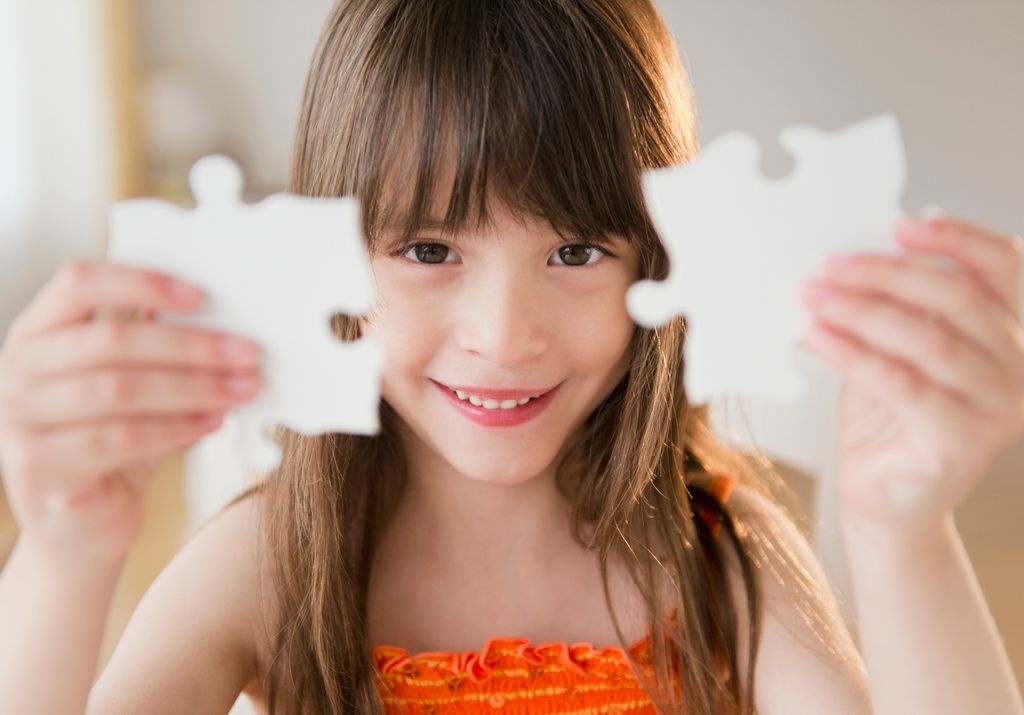 Niña pequeña con dos piezas de un puzle