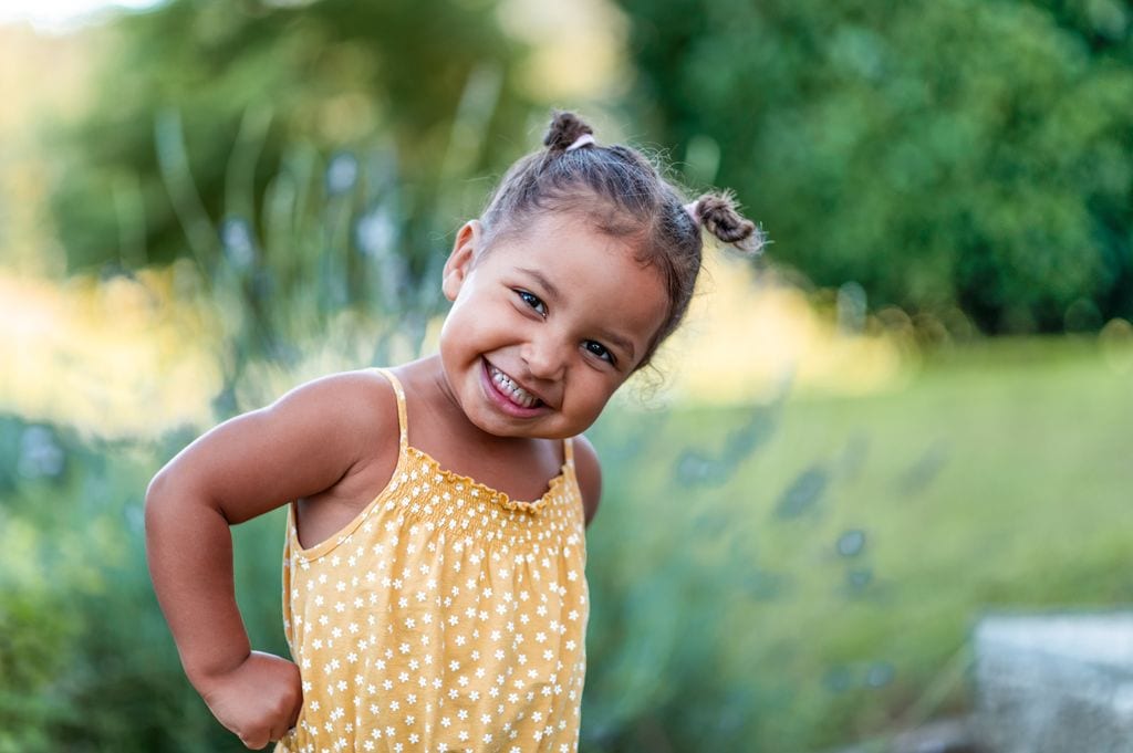 Niña sonríe en el campo