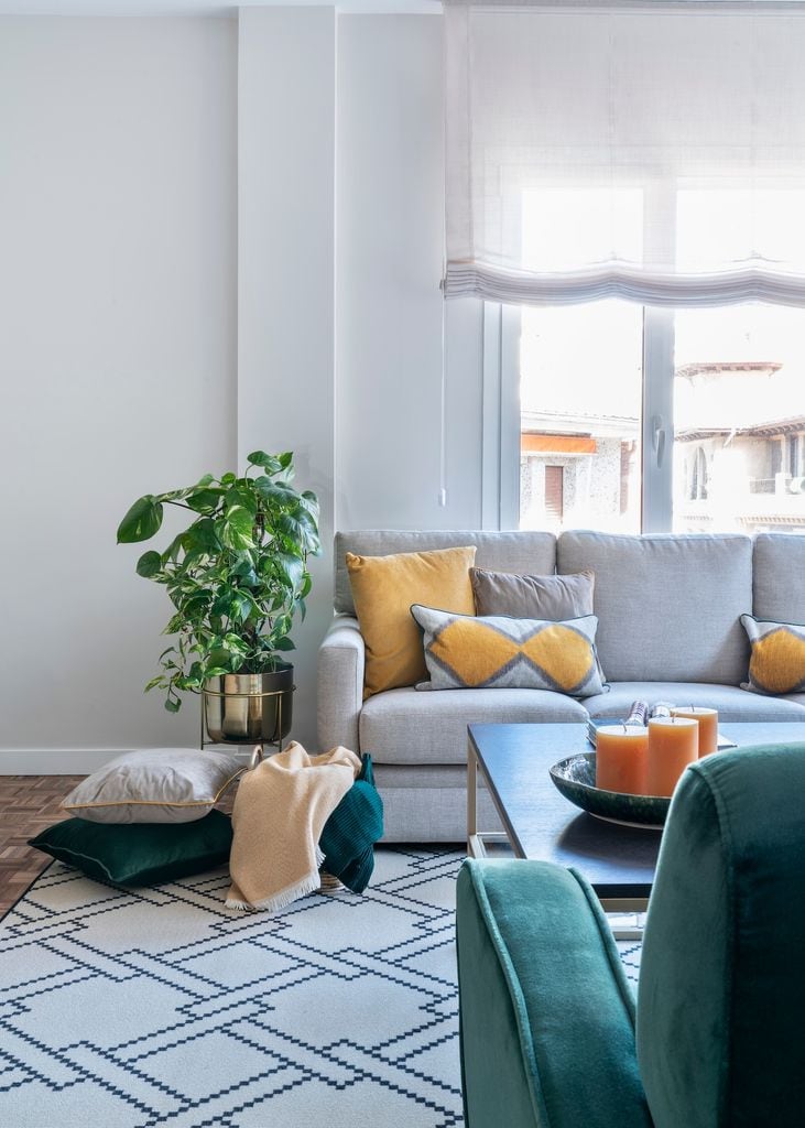 Salón con sofá gris y cojines amarillos.