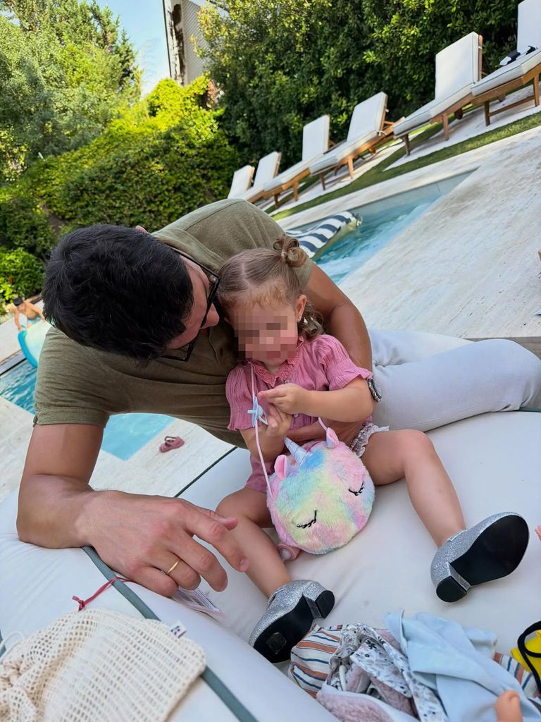 Pablo haciéndole carantoñas a la pequeña Vega con su bolso de unicornio