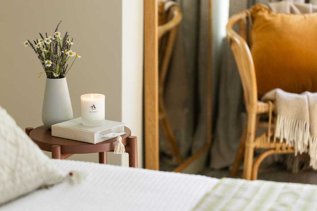 Dormitorio con vela aromática y arreglo floral
