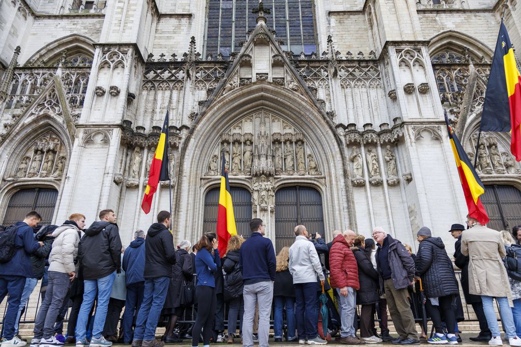 La gente en los alrededores de la catedral de Bruselas para ver llegar a la familia real belga