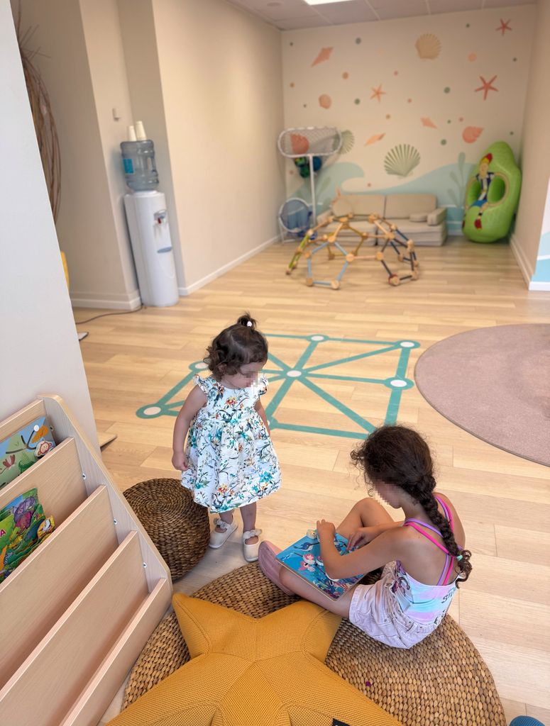 Anaís contempla el libro que le muestra su hermana Aura