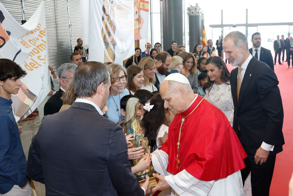 Felipe VI de España y el Papa Francisco entregan una estatua a una niña.