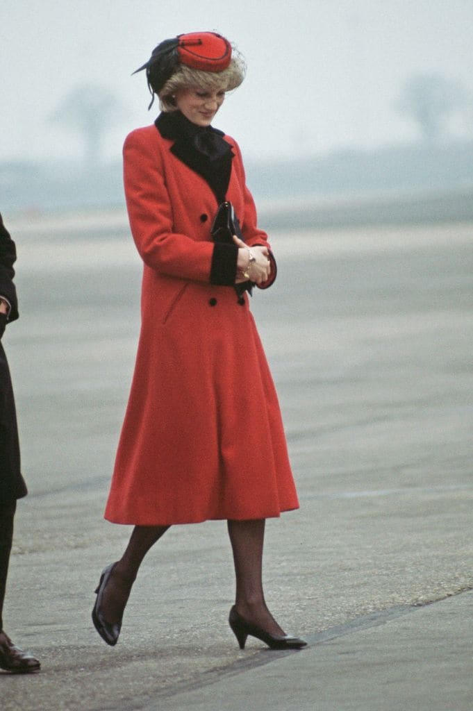 Diana, princesa de Gales, con un abrigo rojo en 1984 en el aeropuerto de Birmingham.