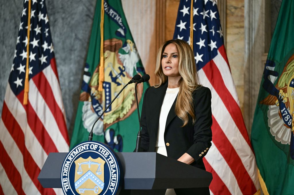 Melania Trump con vestido blanco satinado y americana negra