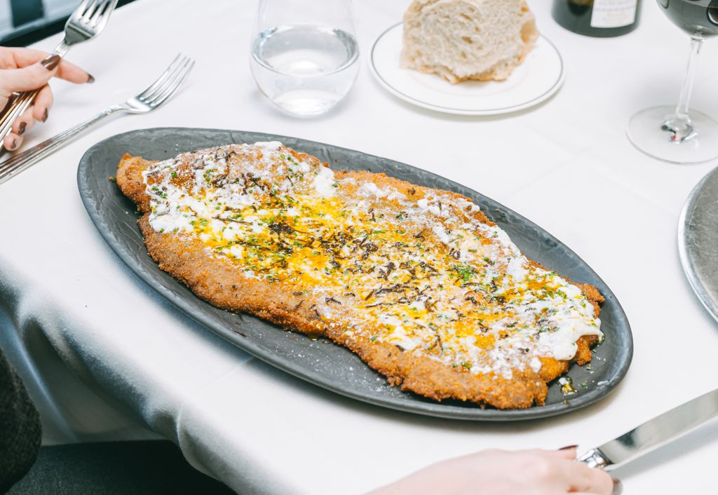 La Milanesa de TATEL, con huevo poché y trufa, es uno de los platos más emblemáticos.