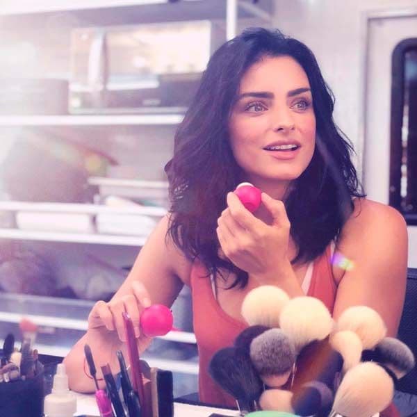 Aislin Derbez en su camerino con un bálsamo labial