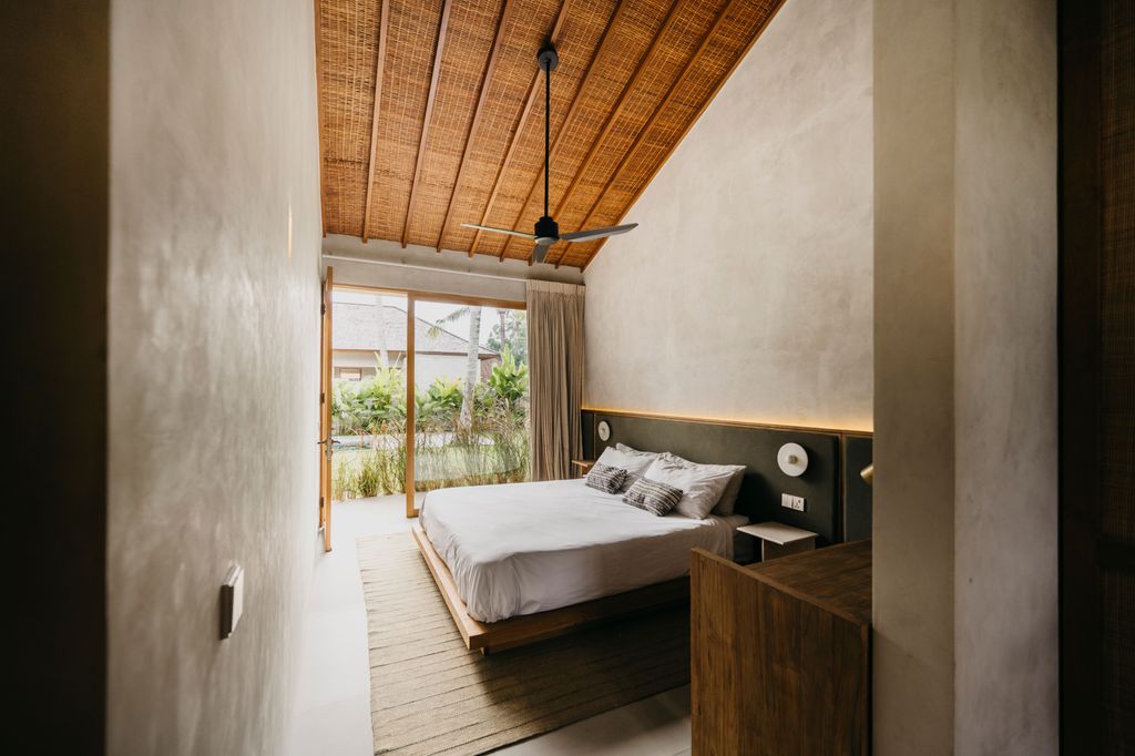 Dormitorio con techo de ratán y vigas de madera