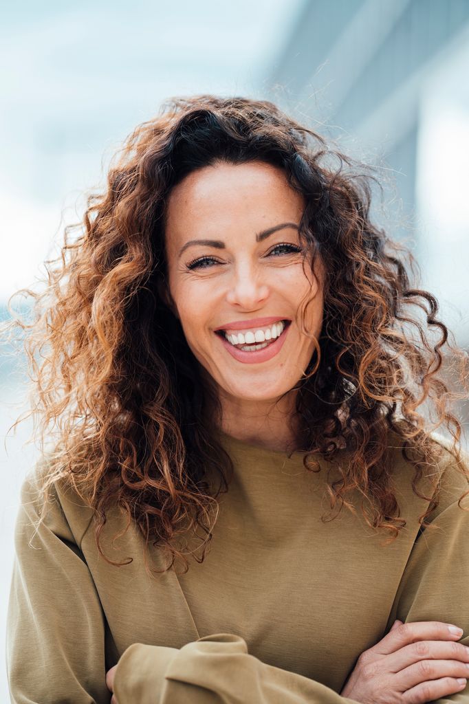 Rostro de mujer madura sonriente con pelo rizado