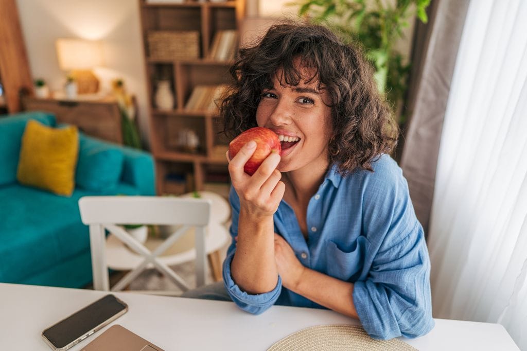 mujer comiendo una manzana roja