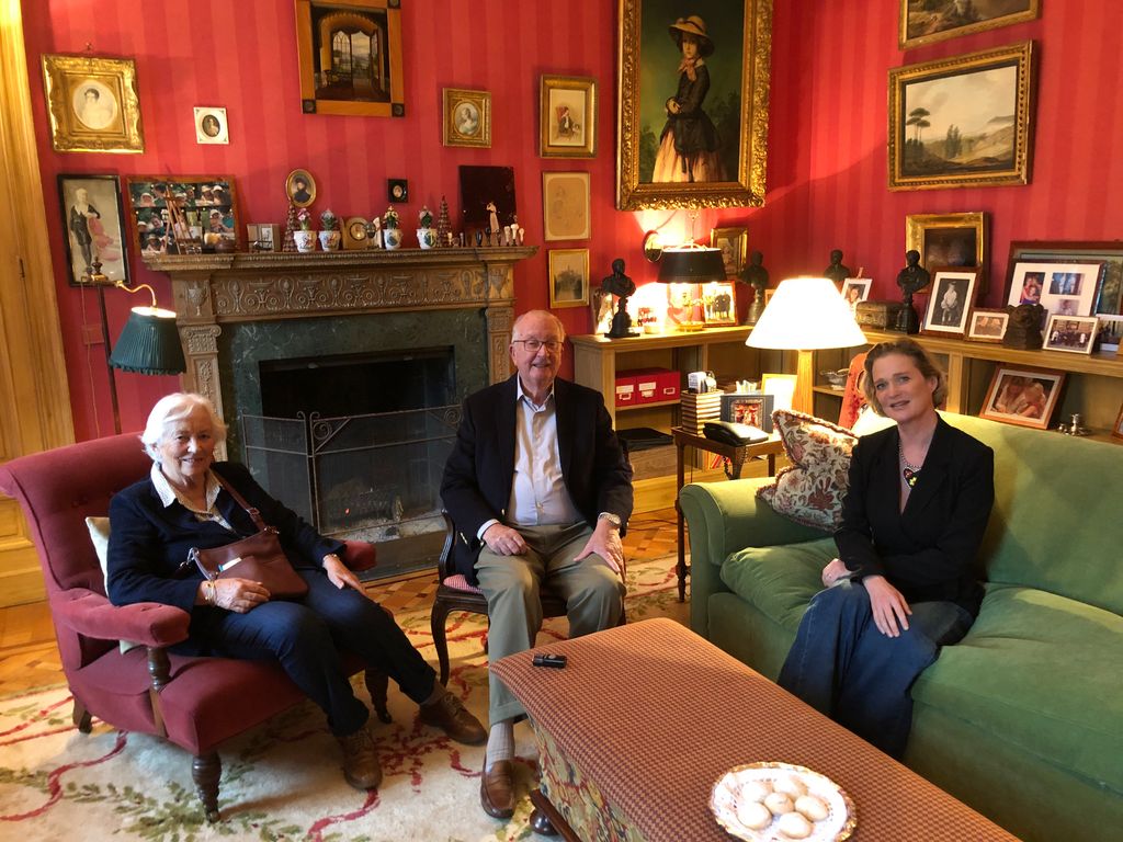 Plano medio de Delphine de Bélgica con la reina Paola y el rey Alberto