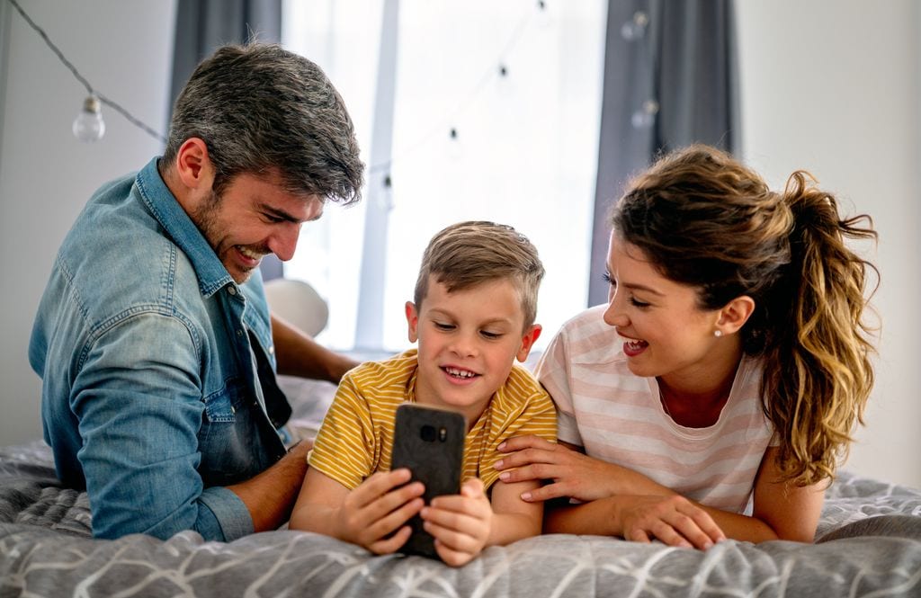 Padres con su hijo pequeño con un móvil