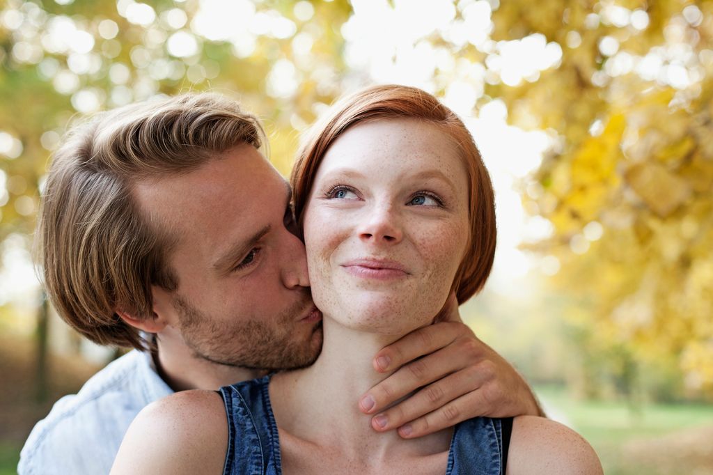 Pareja besándose en el parque demostrando amor