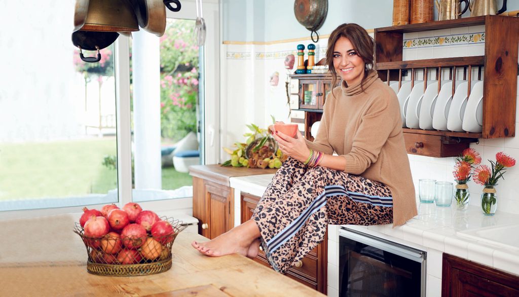 Mariló Montero posa descalza en la cocina de su casa en Sanlúcar, en la estancia destacan las decoración que aporta color gracias a las frutas y las flores