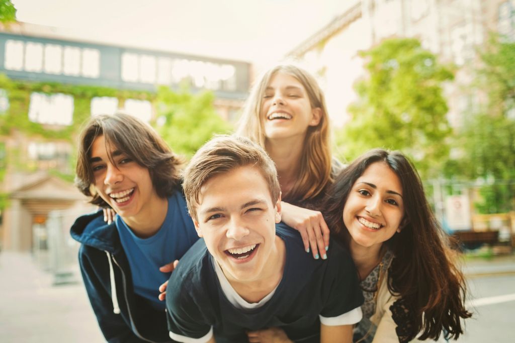 grupo de cuatro adolescentes sonrientes
