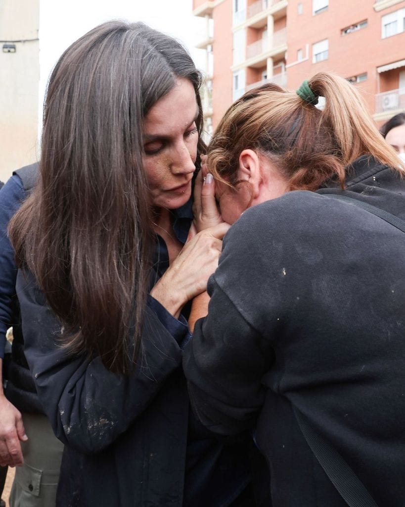 Plano medio de la Reina Letizia consolando a una víctima de la DANA
