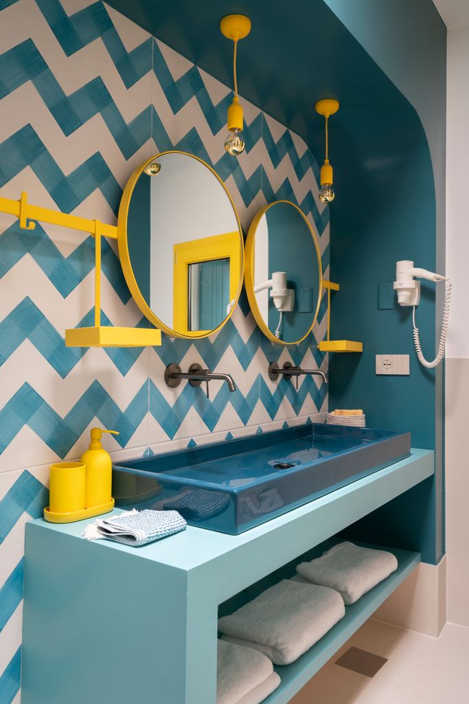 Paola Sola diseña una barra multifunción en el baño, que sostiene los espejos, pero también cestas y ganchos
