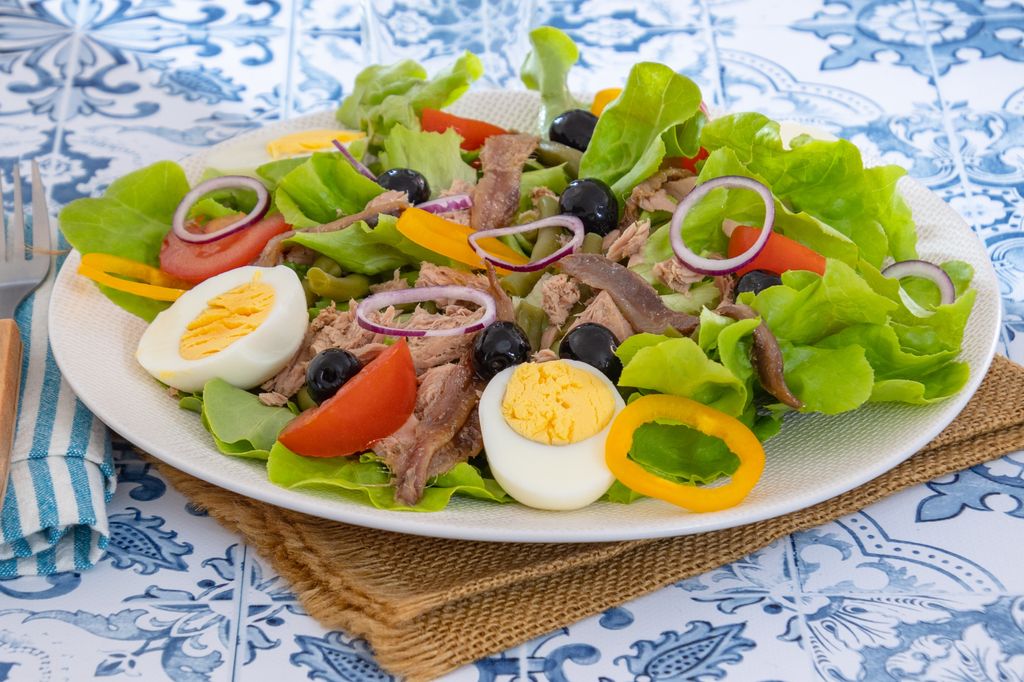 La ensalada niçoise suele llevar atún en lugar de sardinas.