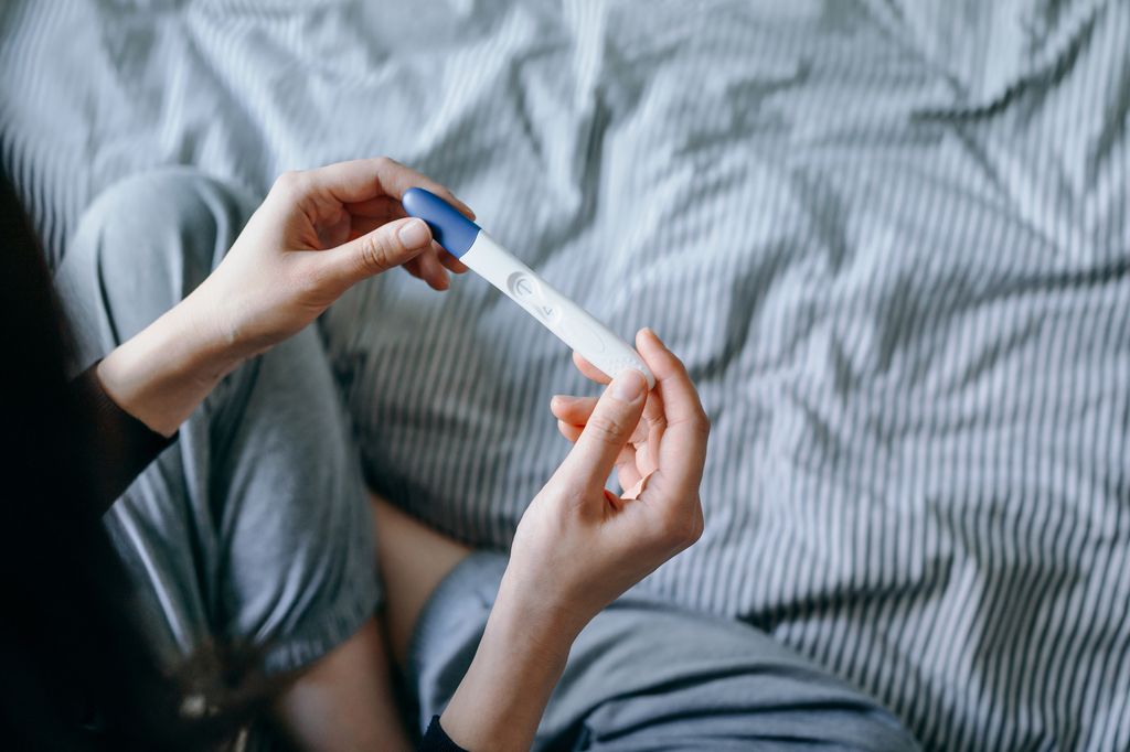 mujer con un test de embarazo en la mano