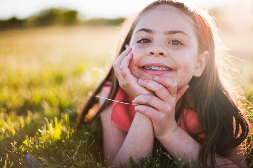 Niña con ortodoncia en el campo