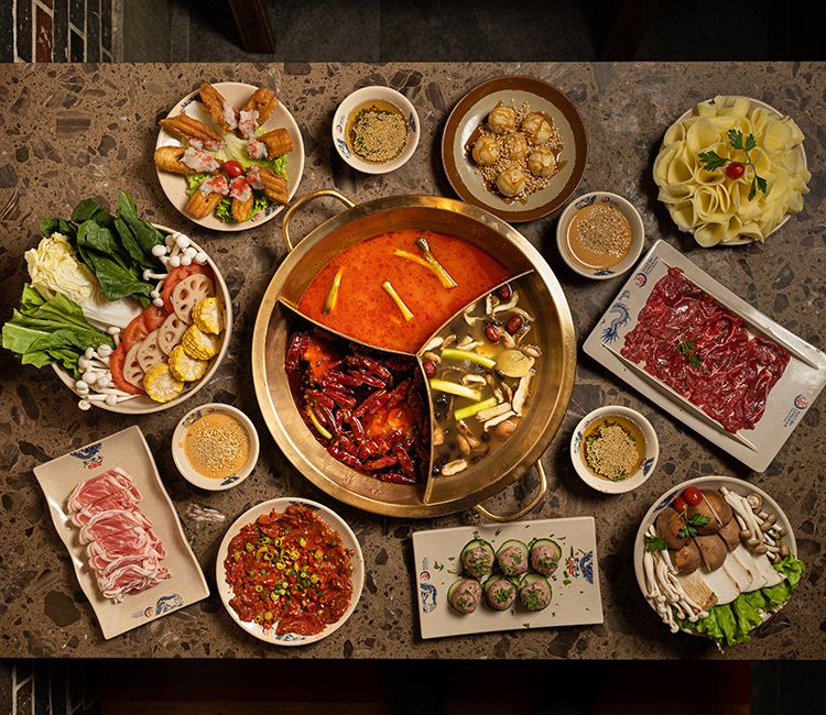 Mesa con ingredientes, caldo y salsas del 'hot pot'