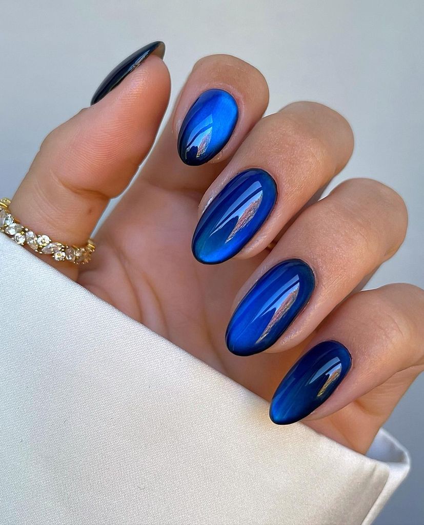 Uñas con efecto ojo de gato en azul rey.