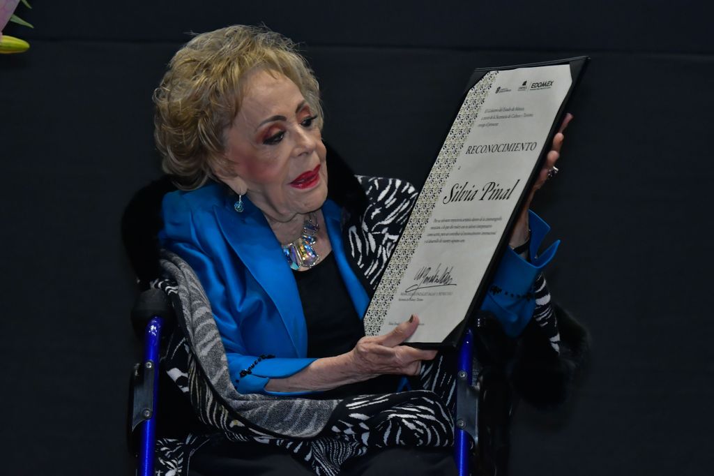 Plano medio de Silvia Pinal sosteniendo un diploma