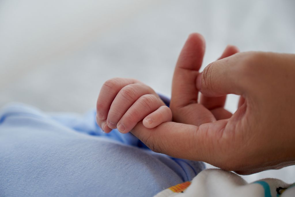 Mano de madre y bebé