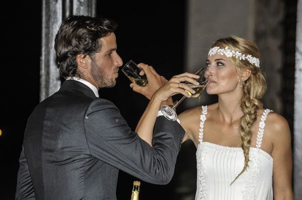 La pareja brindando para las cámaras en el día de su boda
