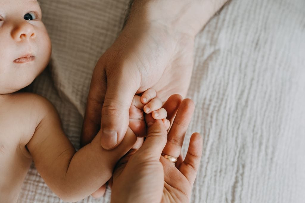 Bebé de la mano de sus padres