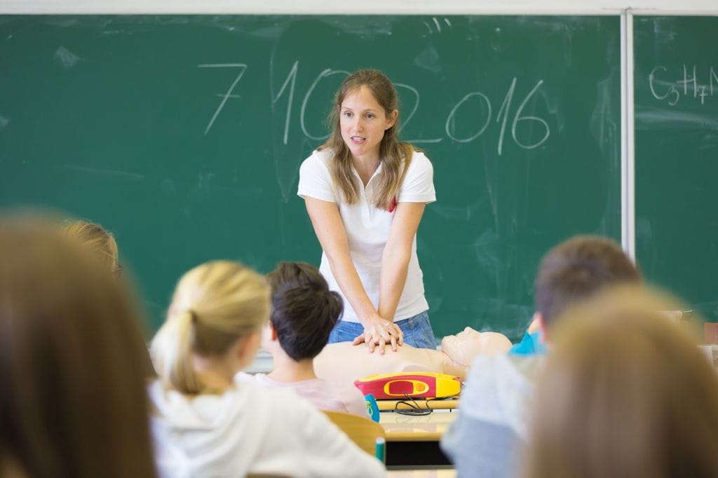 Niños aprendiendo primeros auxilios en clase