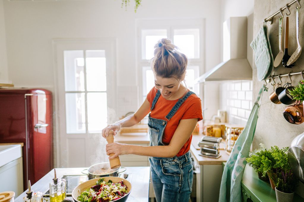 Mujer cocinando con especias que activan el colágeno