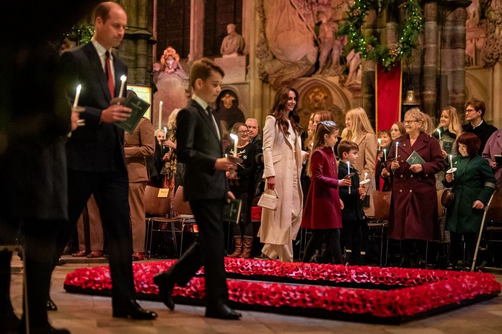 Plano medio de Kate Middleton con el príncipe Guillermo y los Louis, Jorge y Carlota en un evento de navidad