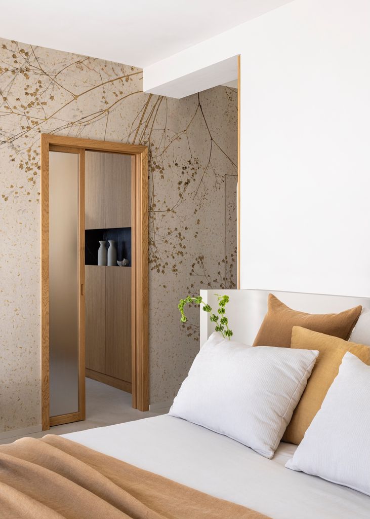 Dormitorio con papel pinyado en tonos ocre. 