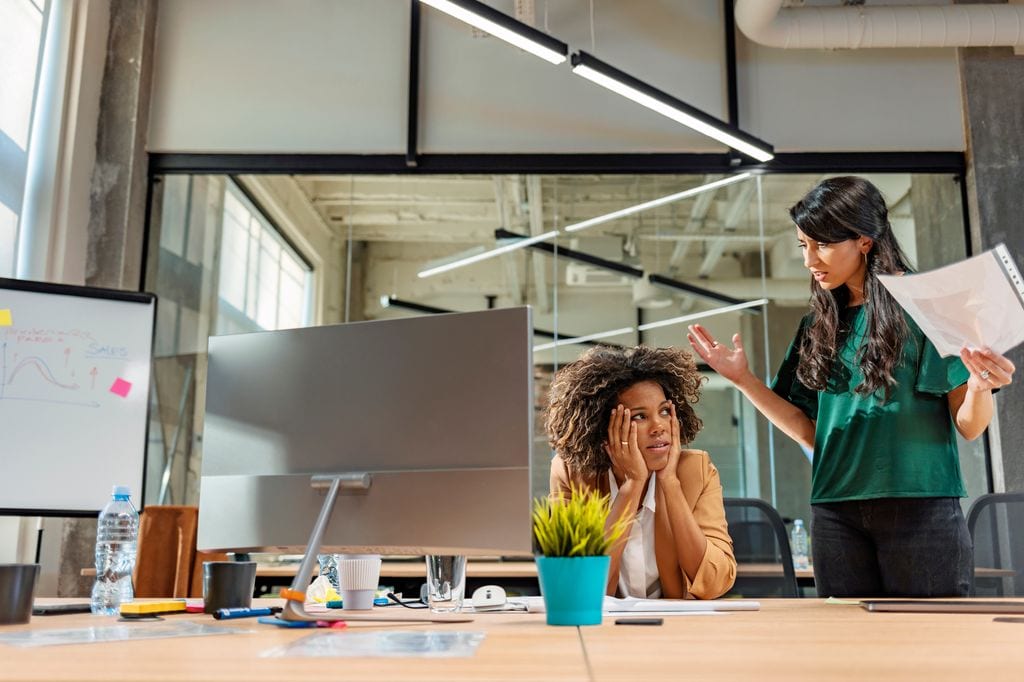 dos compañeras de oficina discutiendo