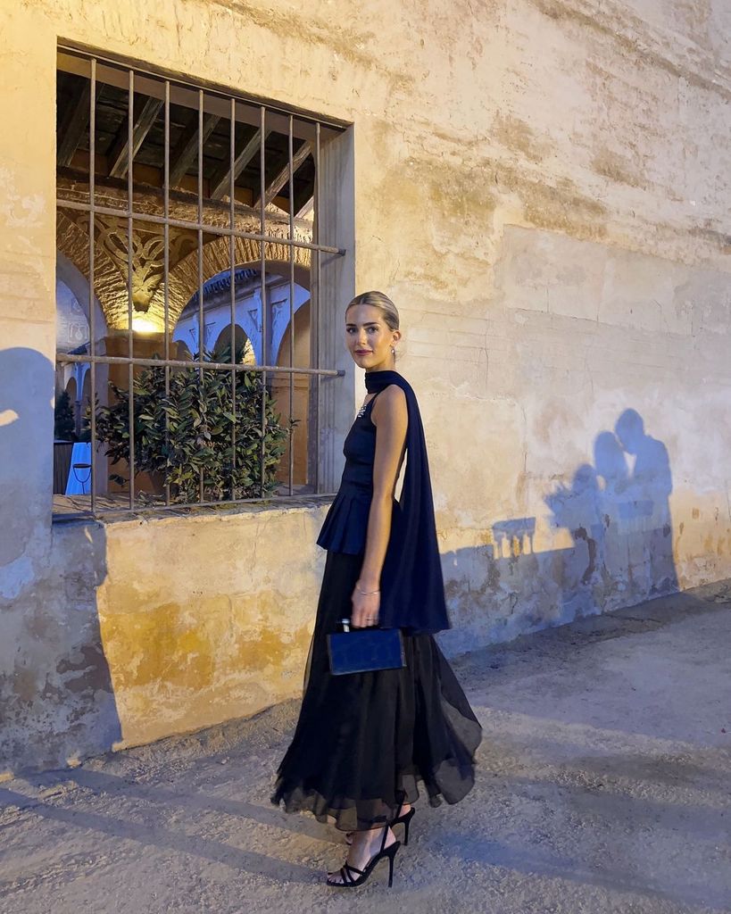 Influencer con look de invitada y capa