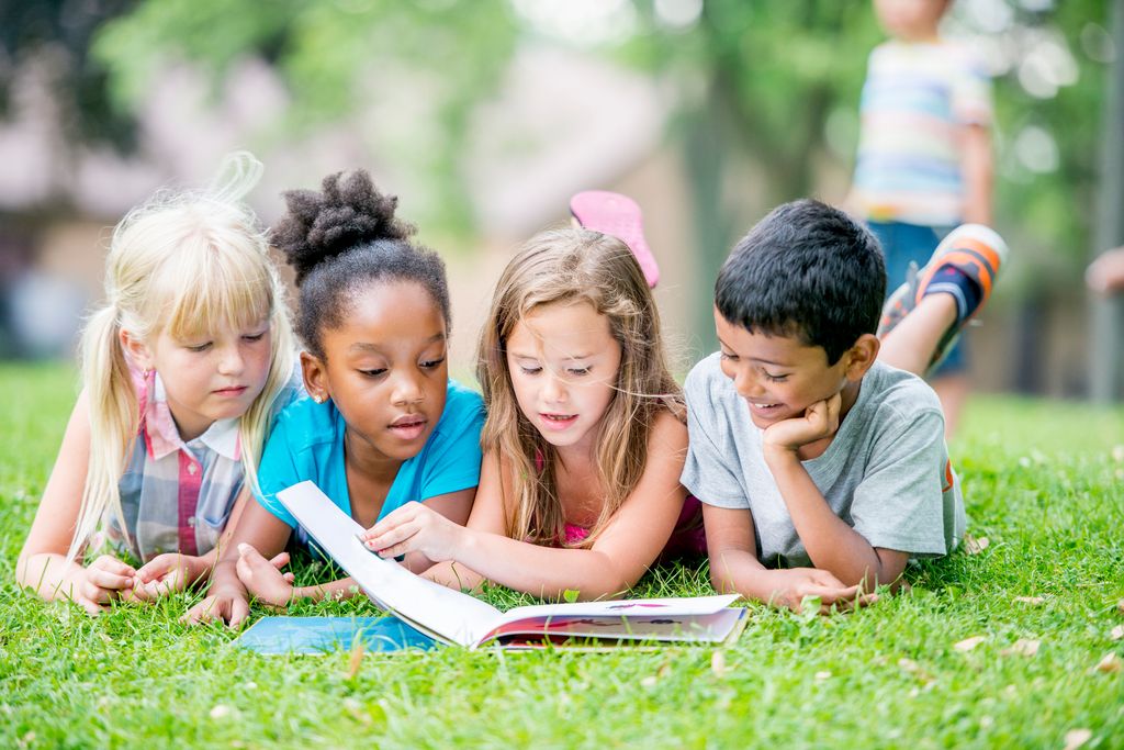 Niños leyendo juntos en el parque