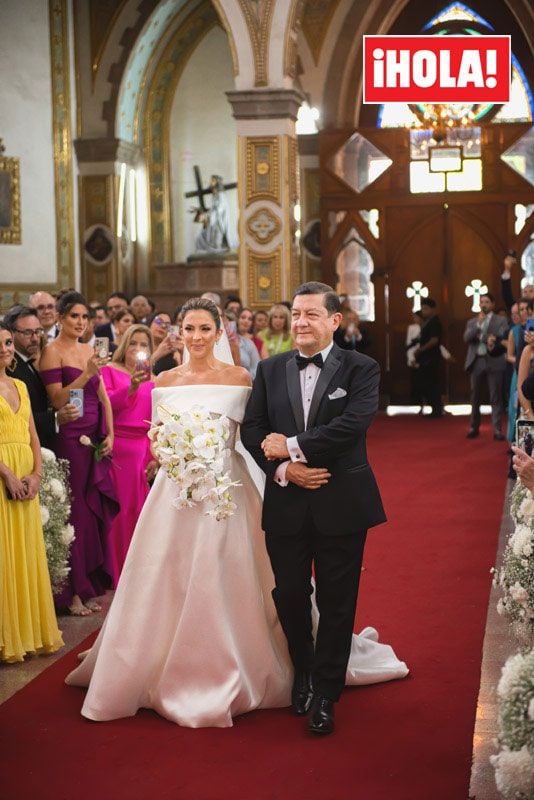 Maity Interiano caminando hacia el altar del brazo de su padre, Ernesto