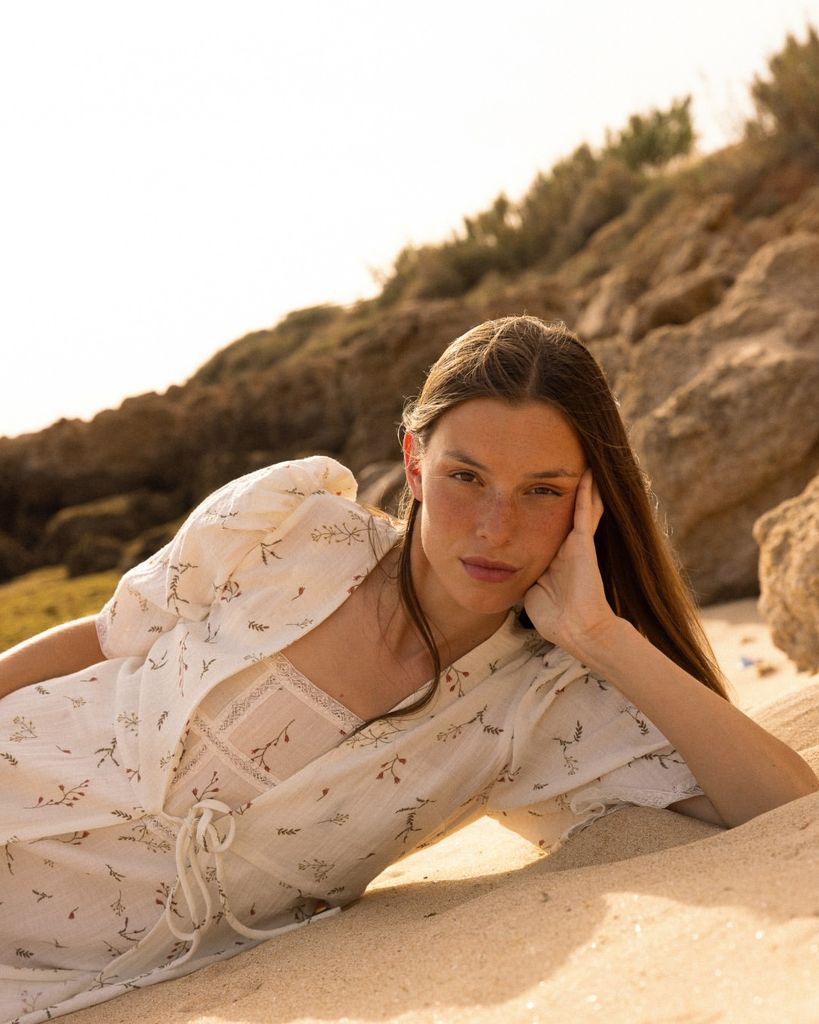 Una chica pensativa mirando a cámara en la playa