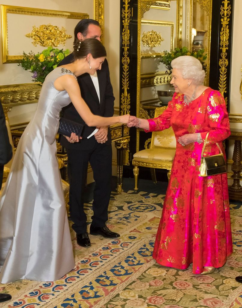 Isabel II con Kendra Spears y Rahim Aga Khan en el castillo de Windsor en 2018