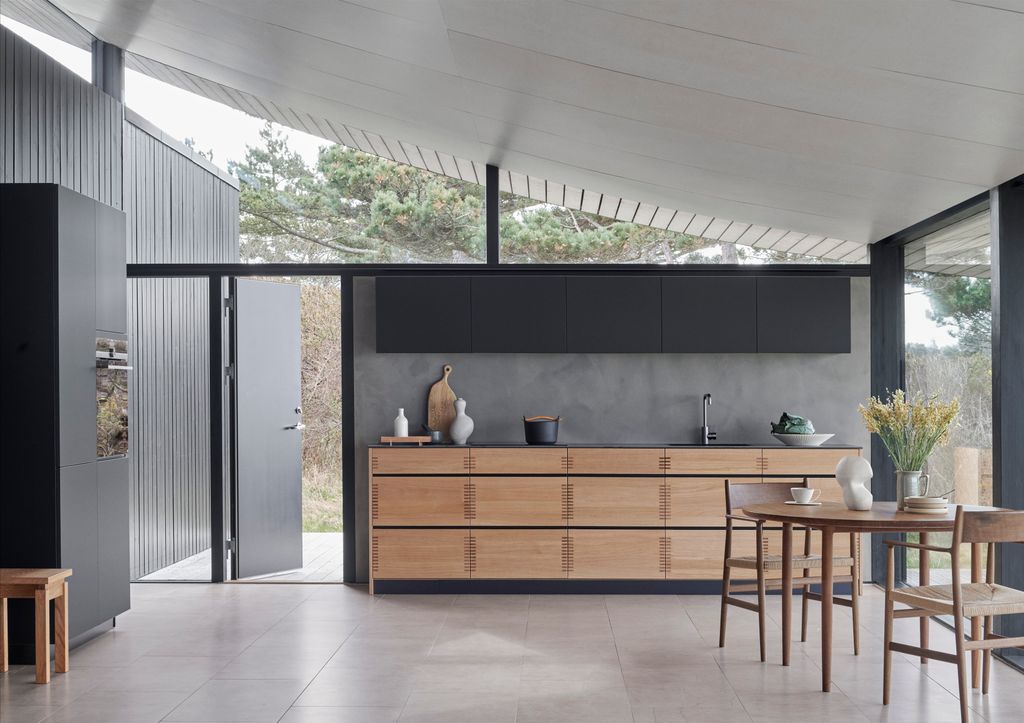 Cocina con muebles de madera en pared negra
