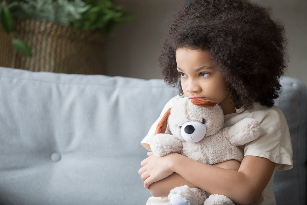 Niña con autismo abrazada a su oso de peluche
