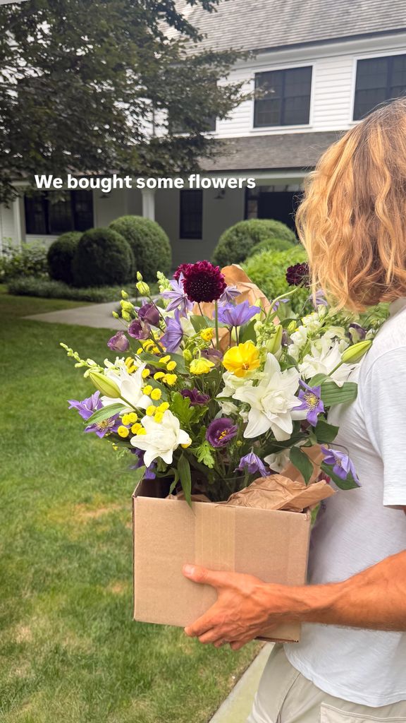 Charlie Schein con unas flores al llegar a su casa de los Hamptons