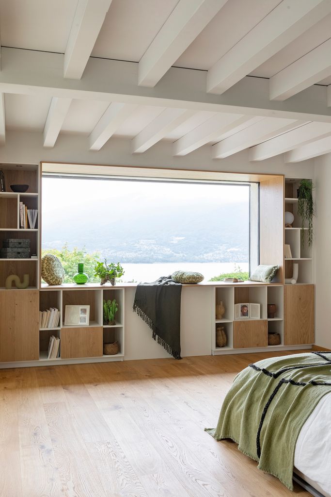 Dormitorio con estantería bajo la ventana. 