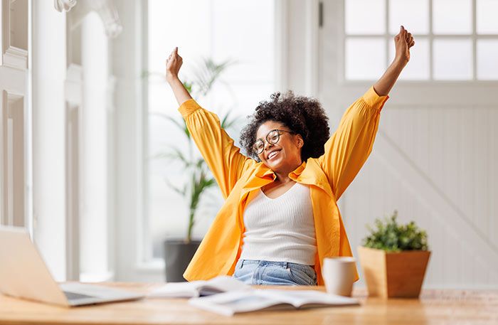 mujer alegre levantando los brazos
