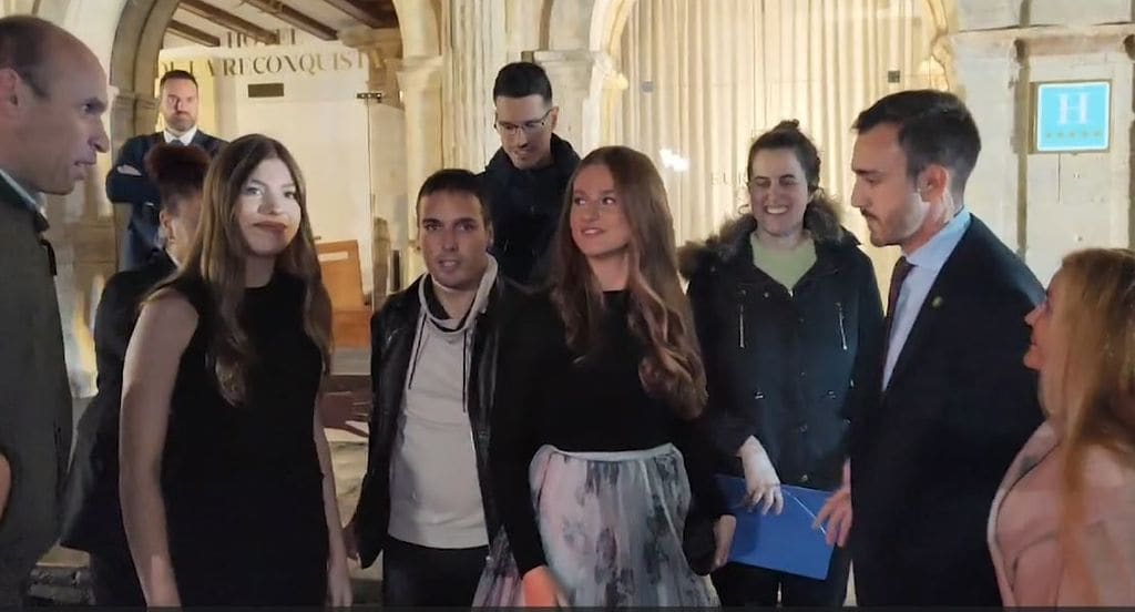 Plano medio de la Princesa Leonor e infanta Sofía haciéndose una foto con un grupo de fans en a la salida del Hotel Reconquista
