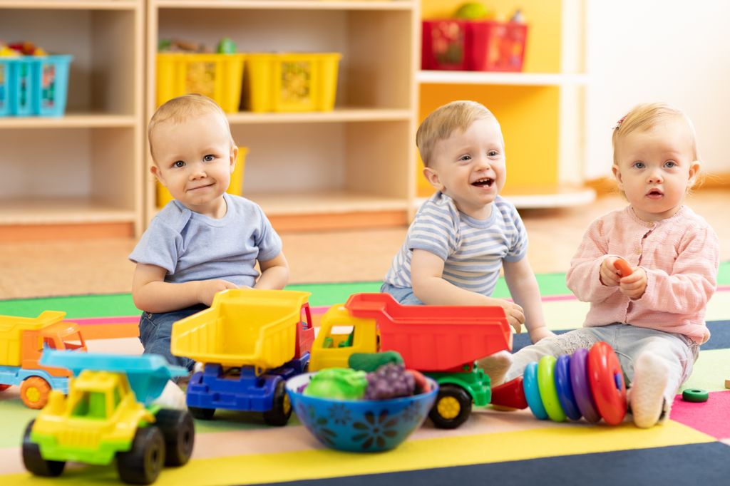 Bebés sentados jugando en el escuela infantil