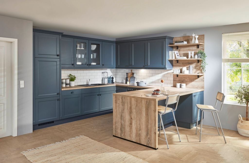 Cocina con barra, muebles azules, taburetes altos, alfombra vitrinas,